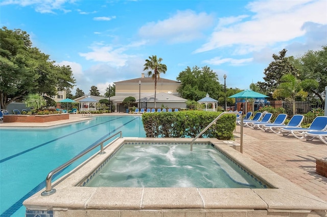 view of swimming pool featuring a community hot tub, a patio, and a gazebo