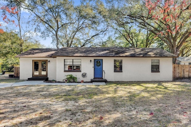 ranch-style home with a front lawn and french doors