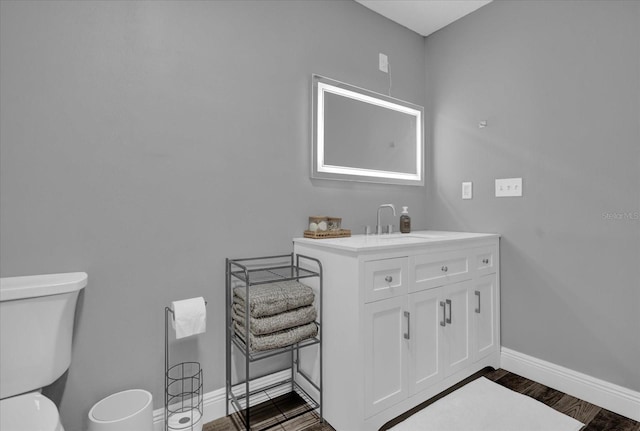 bathroom featuring vanity, hardwood / wood-style flooring, and toilet