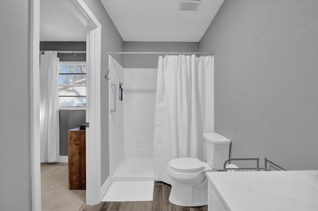 bathroom with hardwood / wood-style floors, vanity, curtained shower, and toilet