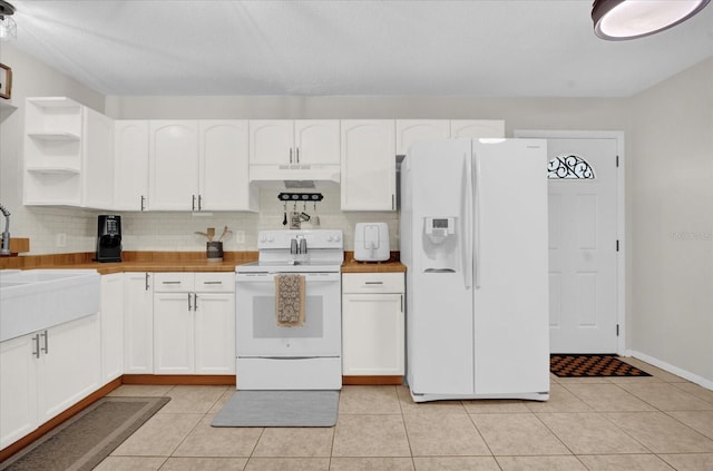 kitchen featuring sink, white appliances, tasteful backsplash, white cabinets, and light tile patterned flooring