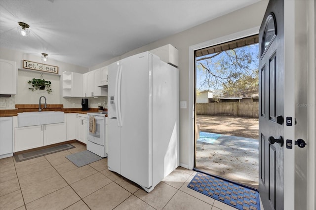 kitchen with butcher block counters, sink, white appliances, and white cabinets