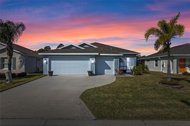 view of front of home featuring a garage and a yard