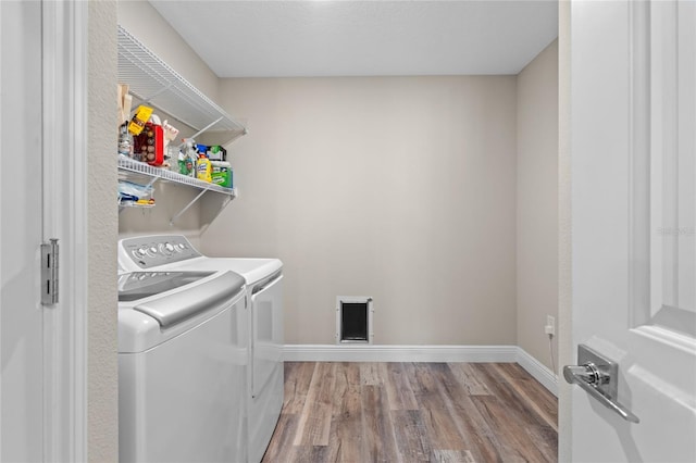 laundry room with separate washer and dryer and wood-type flooring