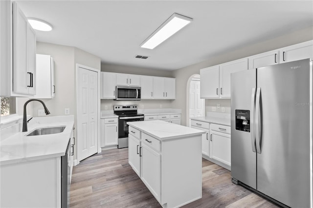 kitchen featuring white cabinetry, sink, a kitchen island, and appliances with stainless steel finishes