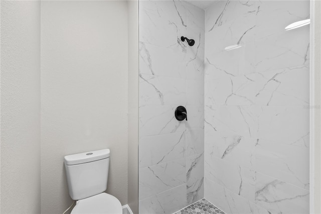 bathroom with tiled shower and toilet