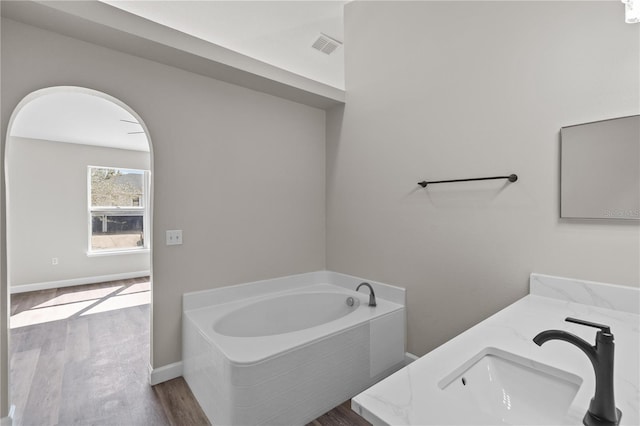 bathroom featuring vanity, wood-type flooring, and a bathing tub