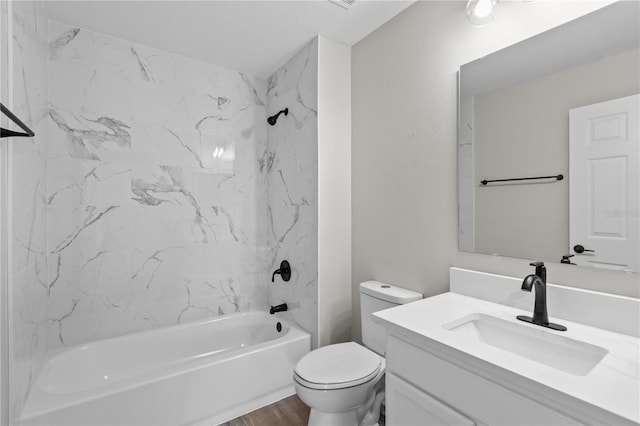 full bathroom featuring tiled shower / bath, wood-type flooring, vanity, and toilet