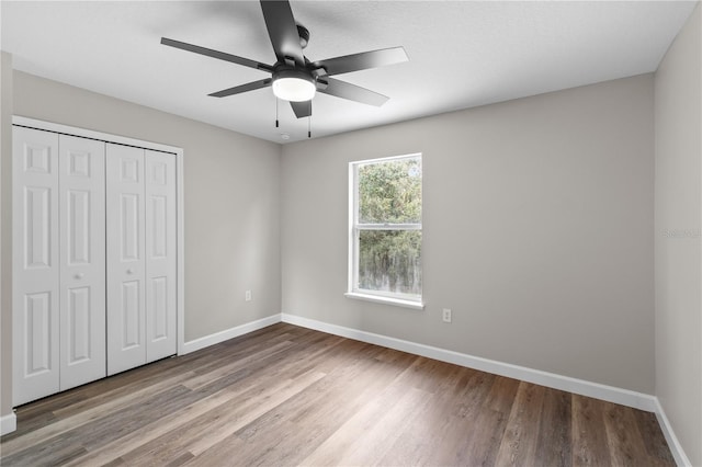 unfurnished bedroom with a closet, ceiling fan, and light wood-type flooring