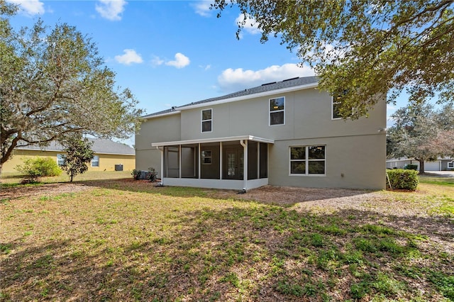 rear view of property with a yard and a sunroom