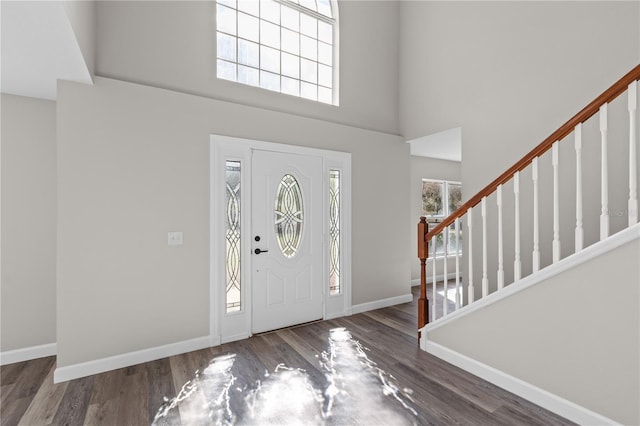 entrance foyer with dark hardwood / wood-style flooring and a high ceiling