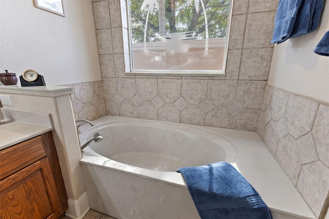 bathroom featuring vanity and a bath