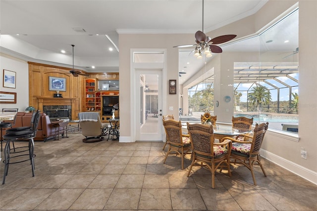 dining space with ornamental molding, a high end fireplace, and ceiling fan