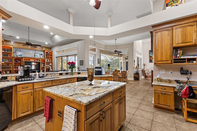 kitchen featuring sink, light stone counters, black dishwasher, a raised ceiling, and a kitchen island