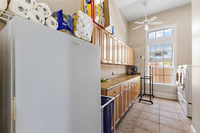 kitchen featuring light tile patterned floors, ceiling fan, range, washing machine and dryer, and white fridge