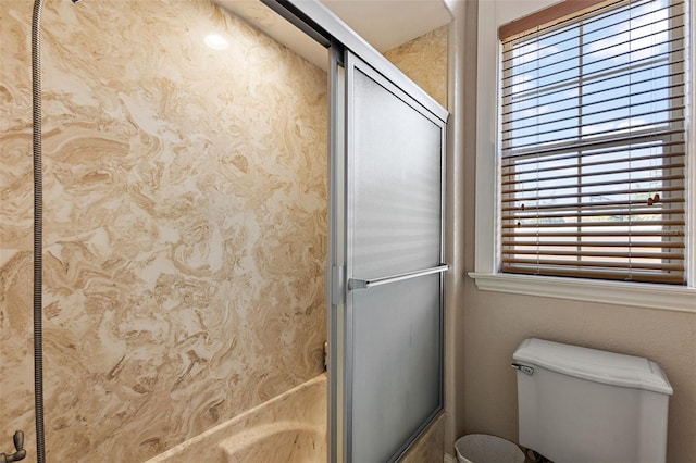 bathroom featuring bath / shower combo with glass door and toilet