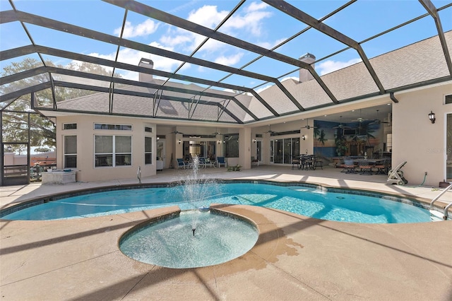 view of pool featuring a lanai, ceiling fan, a patio area, pool water feature, and an in ground hot tub