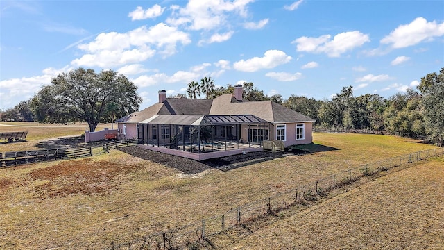 back of house featuring a hot tub, a patio, a yard, and a rural view