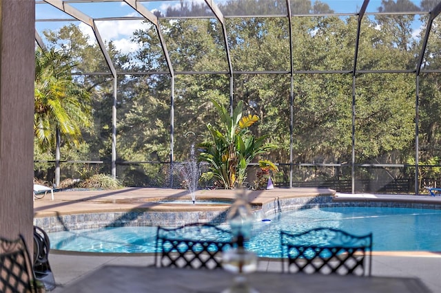 view of pool featuring an in ground hot tub, glass enclosure, and a patio area