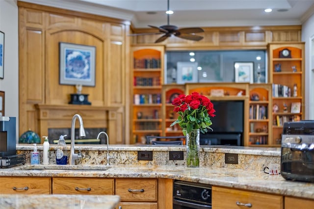 kitchen featuring light stone counters, sink, ornamental molding, and ceiling fan