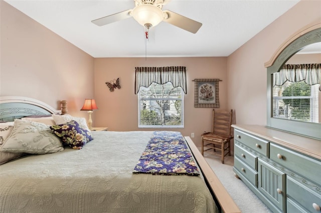 bedroom with multiple windows, light colored carpet, and ceiling fan