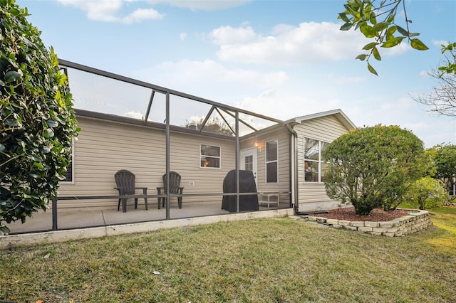 rear view of property featuring a yard, a lanai, and a patio