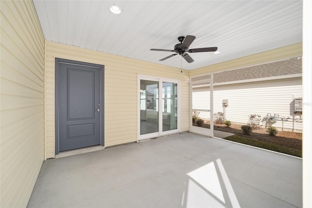 unfurnished sunroom with ceiling fan and a patio area