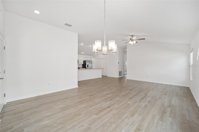 unfurnished living room featuring ceiling fan with notable chandelier and light hardwood / wood-style flooring