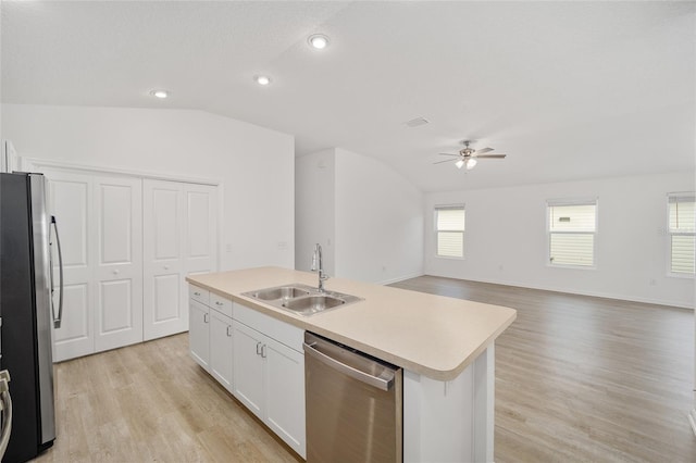 kitchen featuring lofted ceiling, sink, white cabinetry, a center island with sink, and appliances with stainless steel finishes