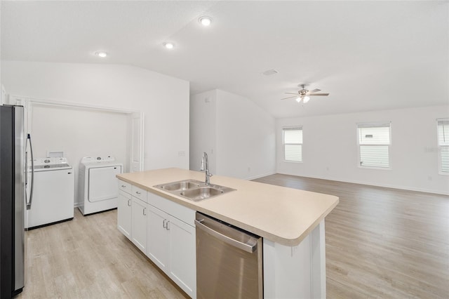 kitchen with an island with sink, white cabinetry, sink, independent washer and dryer, and stainless steel appliances