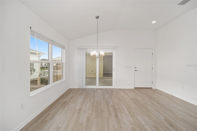 unfurnished dining area featuring an inviting chandelier, lofted ceiling, and light wood-type flooring