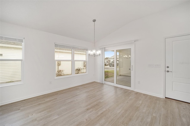 unfurnished dining area with light hardwood / wood-style floors, a chandelier, and vaulted ceiling