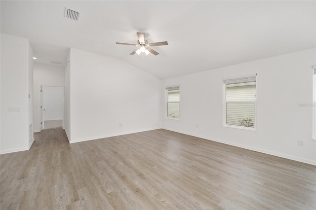 empty room with ceiling fan, vaulted ceiling, and light wood-type flooring