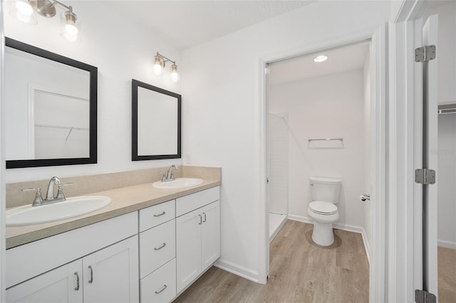 bathroom with wood-type flooring, vanity, and toilet