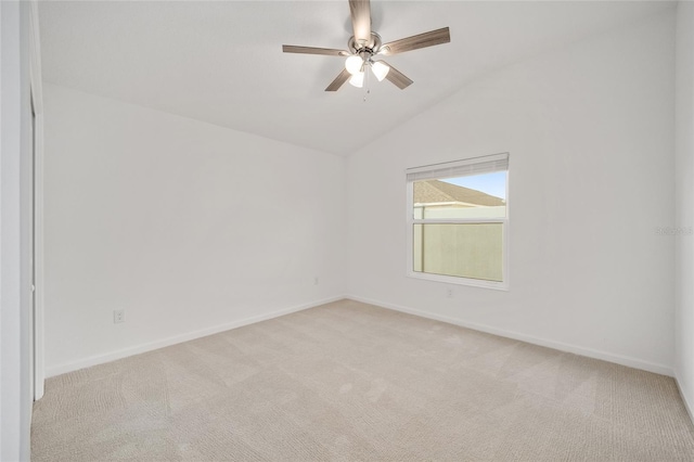 empty room with ceiling fan, vaulted ceiling, and light carpet