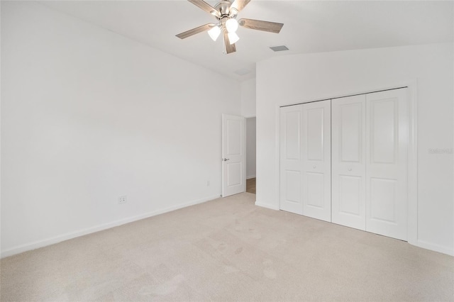 unfurnished bedroom with light carpet, lofted ceiling, a closet, and ceiling fan