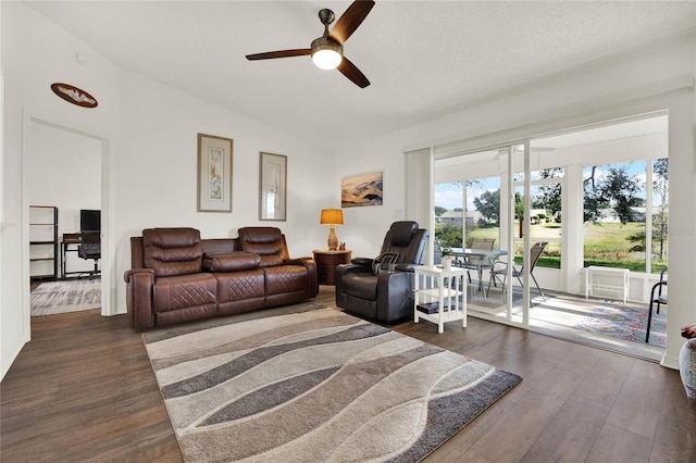 living room featuring dark wood-type flooring and ceiling fan