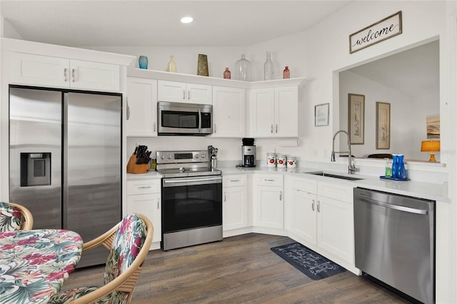 kitchen featuring white cabinetry, stainless steel appliances, dark wood-type flooring, and sink