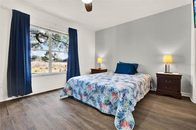 bedroom featuring ceiling fan, dark hardwood / wood-style floors, and a textured ceiling