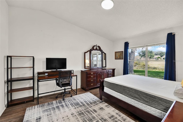 bedroom with dark wood-type flooring, lofted ceiling, and a textured ceiling