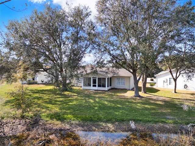 ranch-style house featuring a sunroom and a front yard