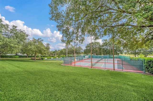 view of tennis court featuring a yard