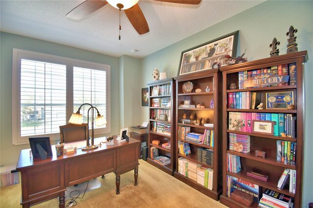 office space featuring ceiling fan, light colored carpet, and a textured ceiling