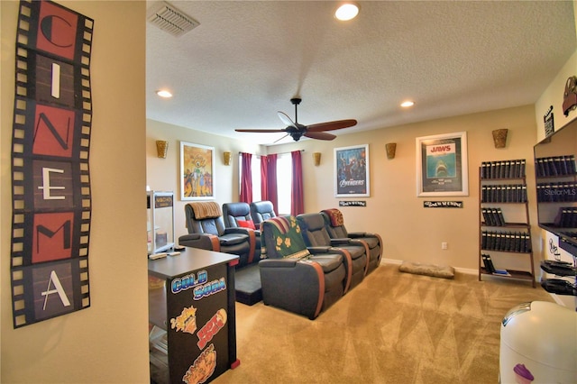 carpeted cinema room featuring ceiling fan and a textured ceiling