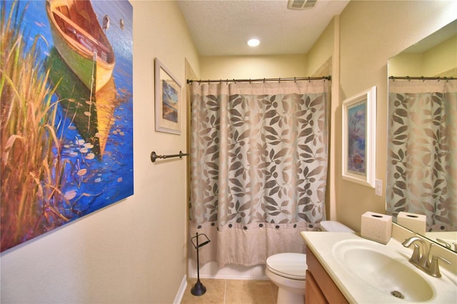 bathroom featuring tile patterned flooring, vanity, toilet, and a textured ceiling