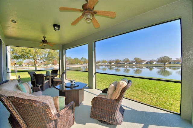 sunroom / solarium with a water view and ceiling fan