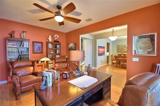 office space featuring ceiling fan, a textured ceiling, and light hardwood / wood-style flooring