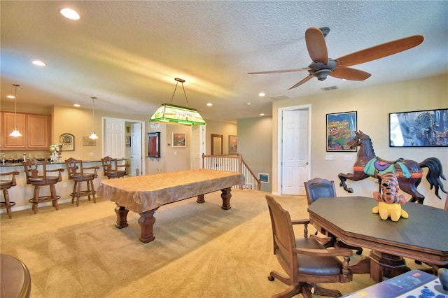 rec room with pool table, light carpet, a textured ceiling, indoor bar, and ceiling fan