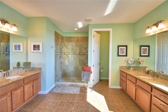 bathroom with an enclosed shower, vanity, tile patterned floors, and a textured ceiling