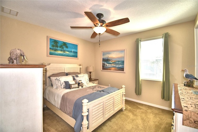 carpeted bedroom featuring ceiling fan and a textured ceiling